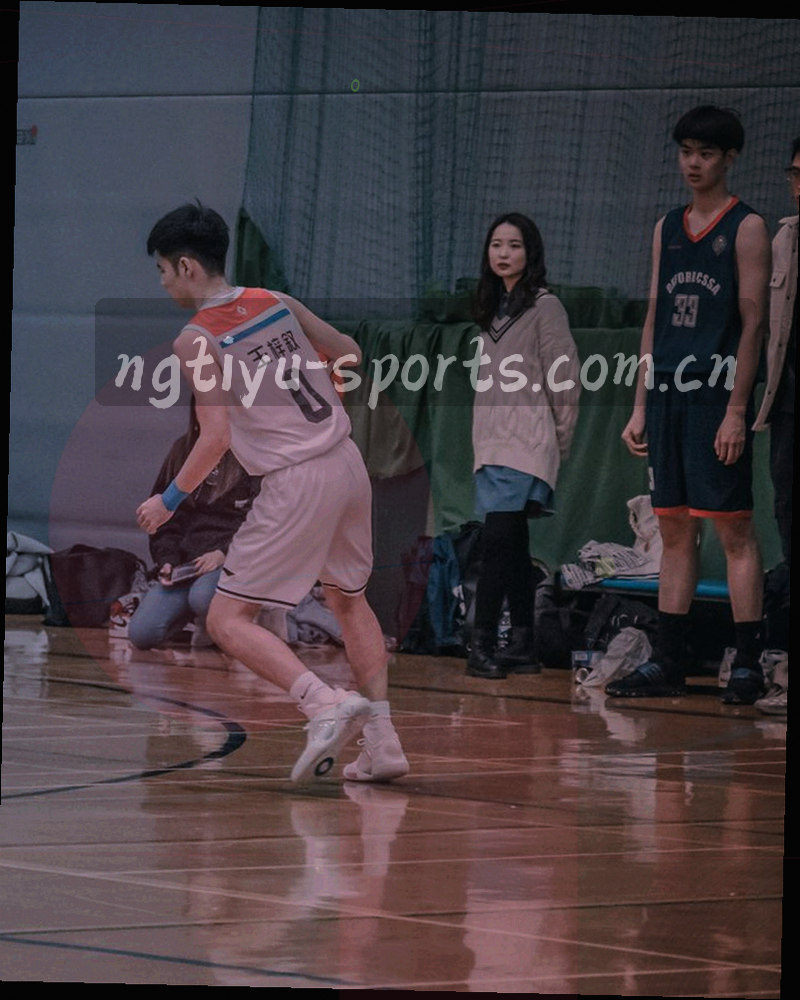 夜间赛场边线与灯光在低角度下形成反光，画面右下留出大片暗部空间